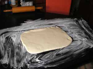 Den Fondant, den ich vorher hergestellt habe, rolle ich nun aus. Immer vorsichtig, damit er nicht reißt, und immer wieder Stärke darunter verteilen.