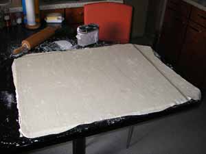 Nachdem er die entsprechende Größe hat, habe ich vorsichtig ein Brett in gleicher Größe darunter geschoben. Das Brett habe ich vorher auch sorgfältig mit Stärke bestäubt.